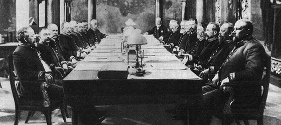 Mustavalkoinen valokuva, jossa senaatin jäsenet istuvat pitkän pöydän ääressä totisina.